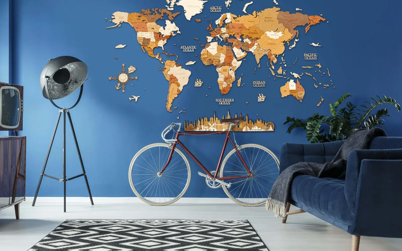 Large multitone 68travel wooden world map with country labels, islands and accessories on a blue living-room wall